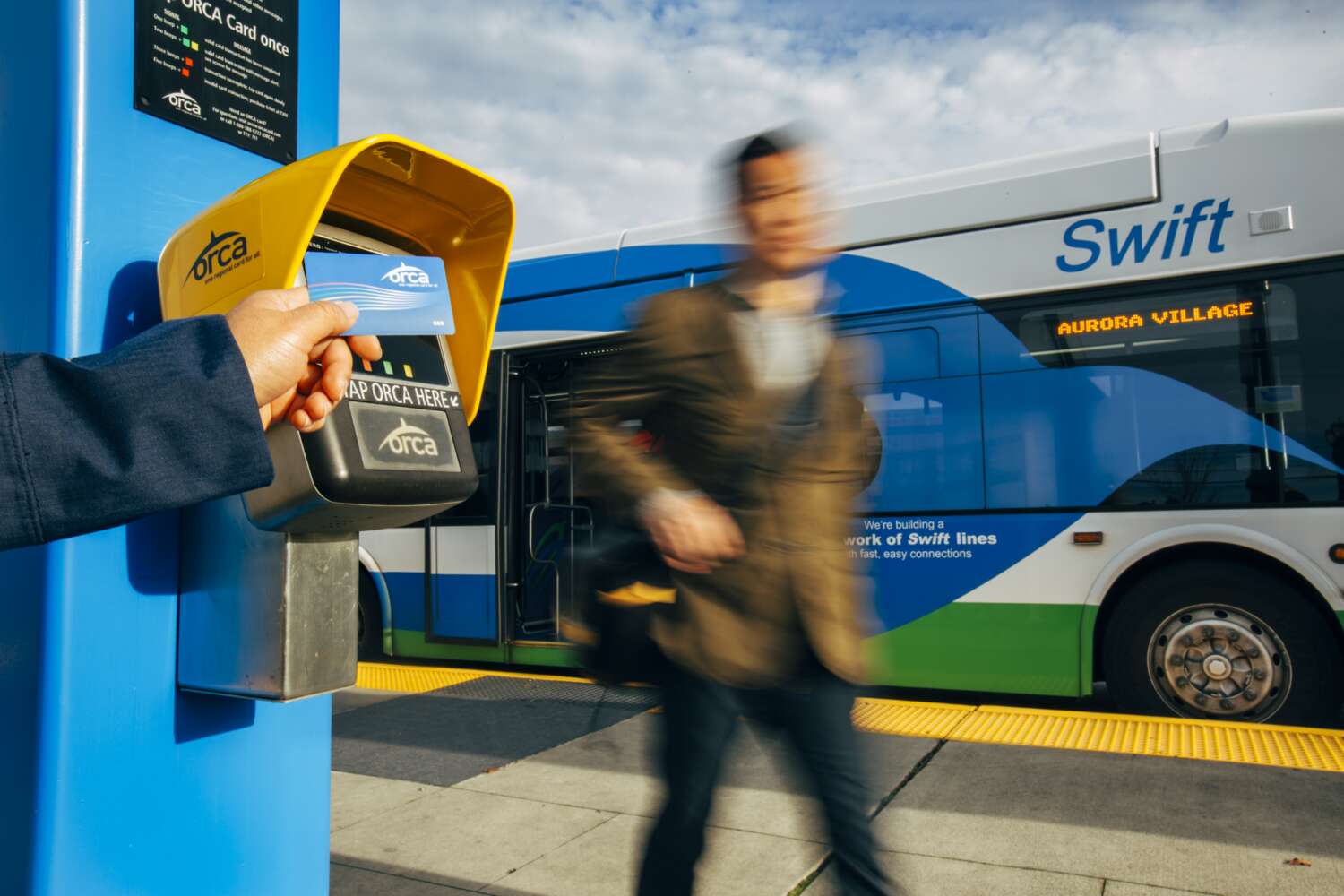 Rider taps ORCA card at a Swift station